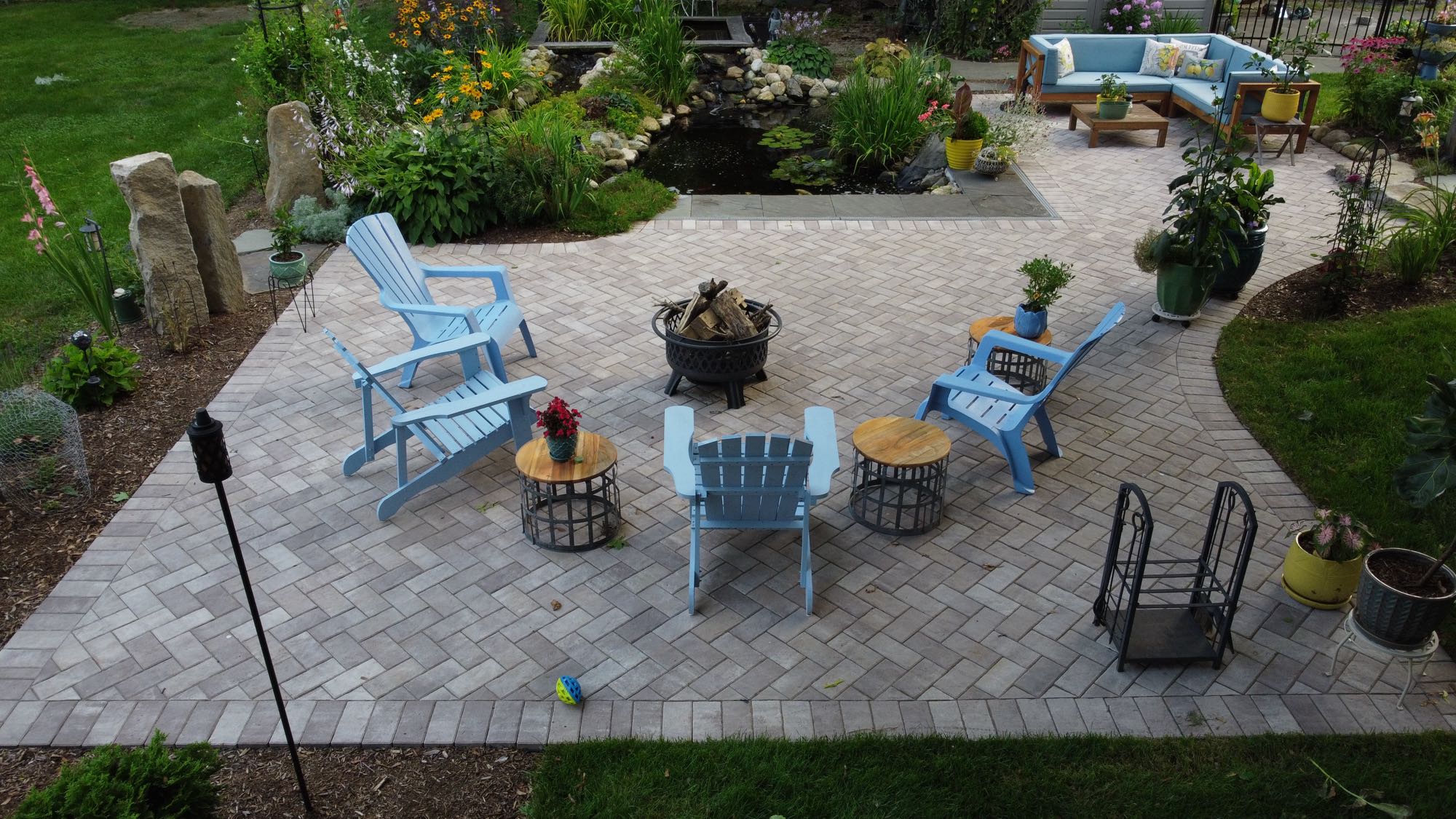 Arnold Ave project; pavers and natural stone with koi pond, sectional, Adirondack chairs and beautiful landscaping