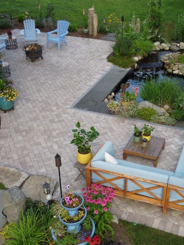 Arnold Ave project; pavers and natural stone with koi pond, sectional, Adirondack chairs and beautiful landscaping