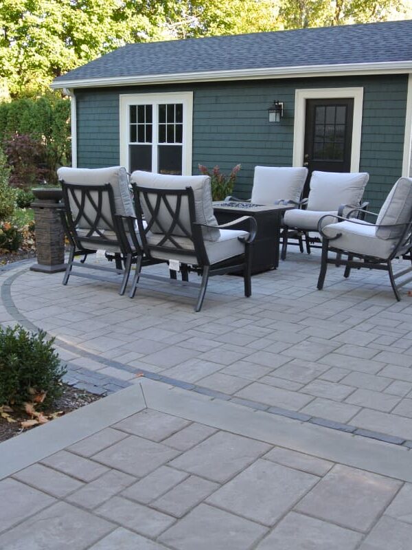 Greene Street project; small paver patio with fire pit and cushioned seating in front of stylish shed/garage