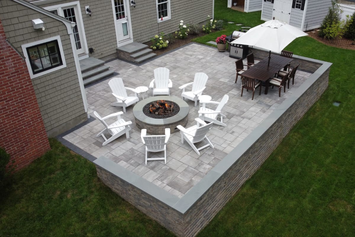 Half Mile road project; small paver patio with stone wall and two stone stairs to back doors