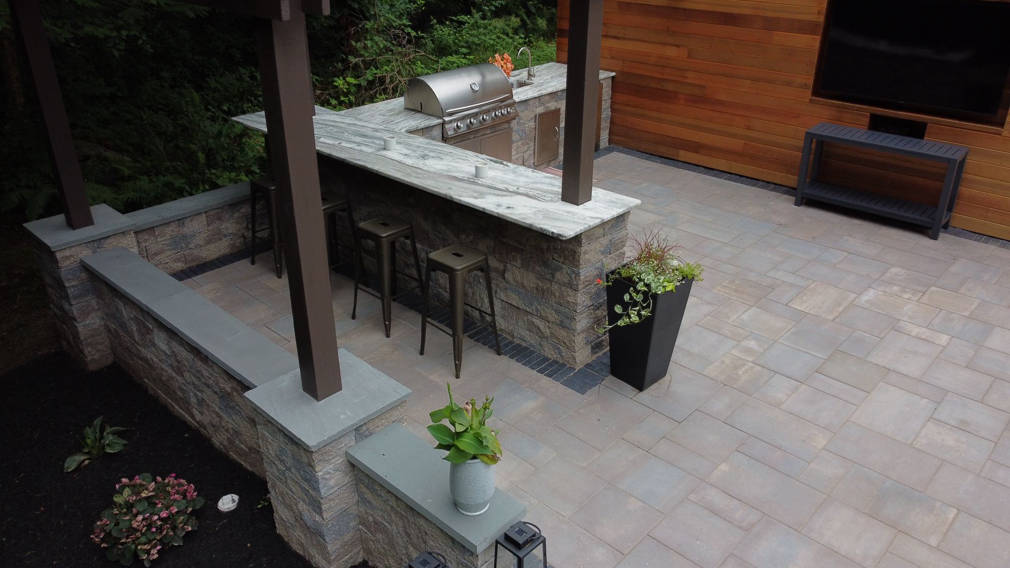 Howland Road project; paver patio with stone bar and outdoor kitchen with grill and bar with barstools and a pergola