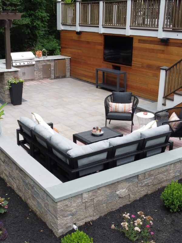 Howland Road project; paver patio entertainment area with stone wall, bar, and grill area in front of a large wooden deck