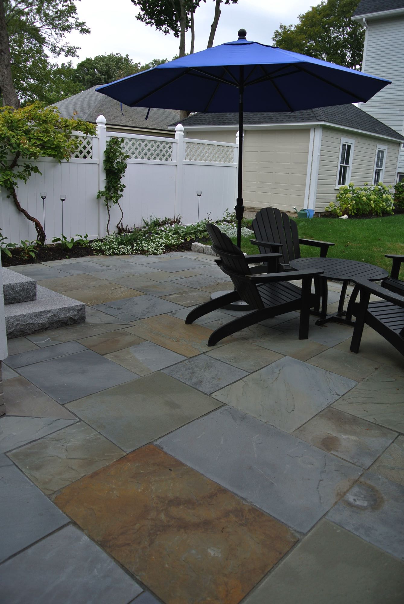 Prospect Street project; natural stone patio with Adirondack chairs and umbrella