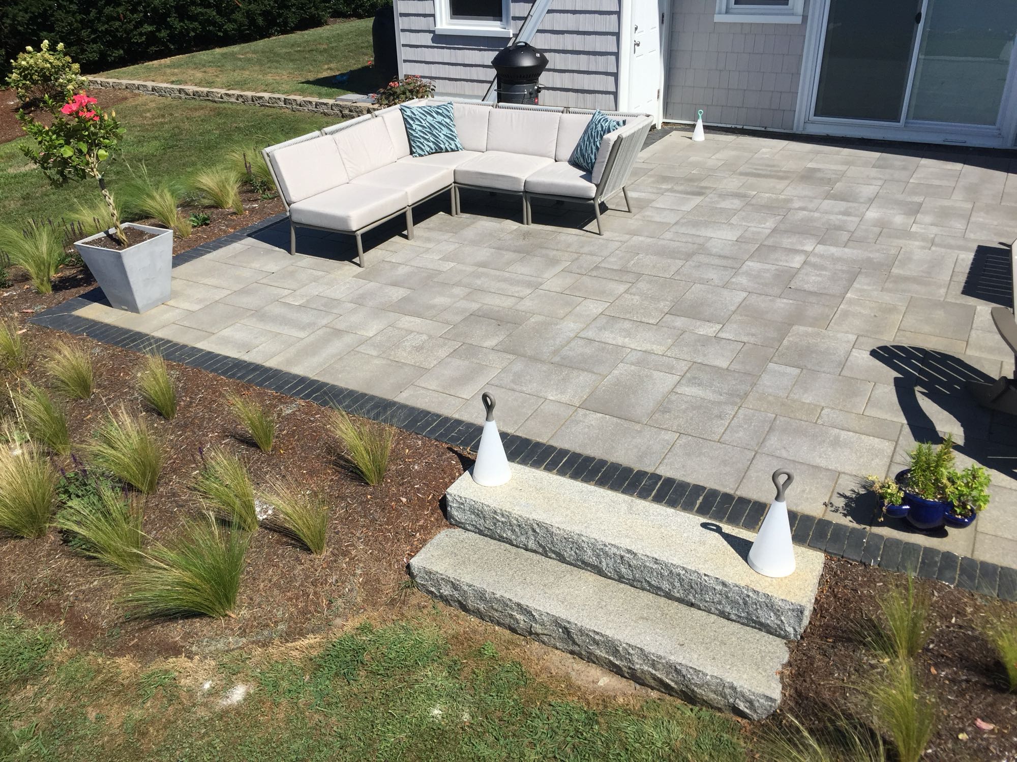 Sapowet patio project; view of small paver patio and natural stone steps with outdoor sectional couch