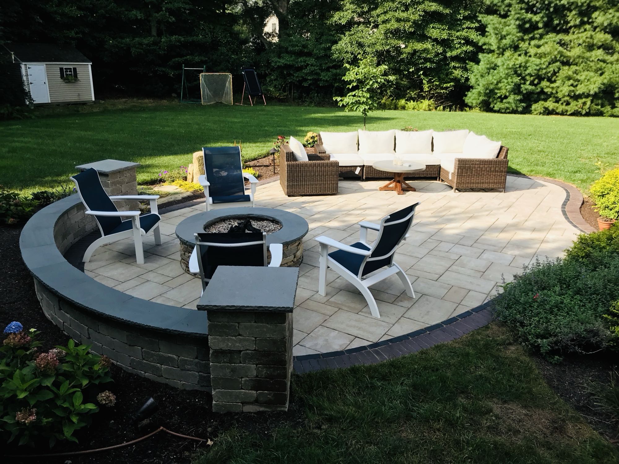 Sylvan Court project; paver patio with short wall around fire pit area and section couch area