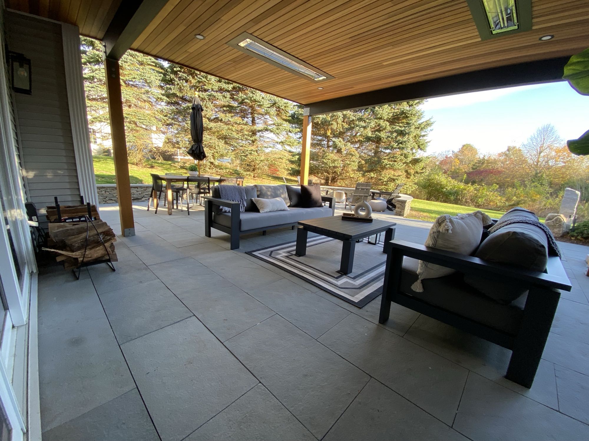 Wild Rose project; large stone patio with border wall, covered seating area, dining area and fire pit