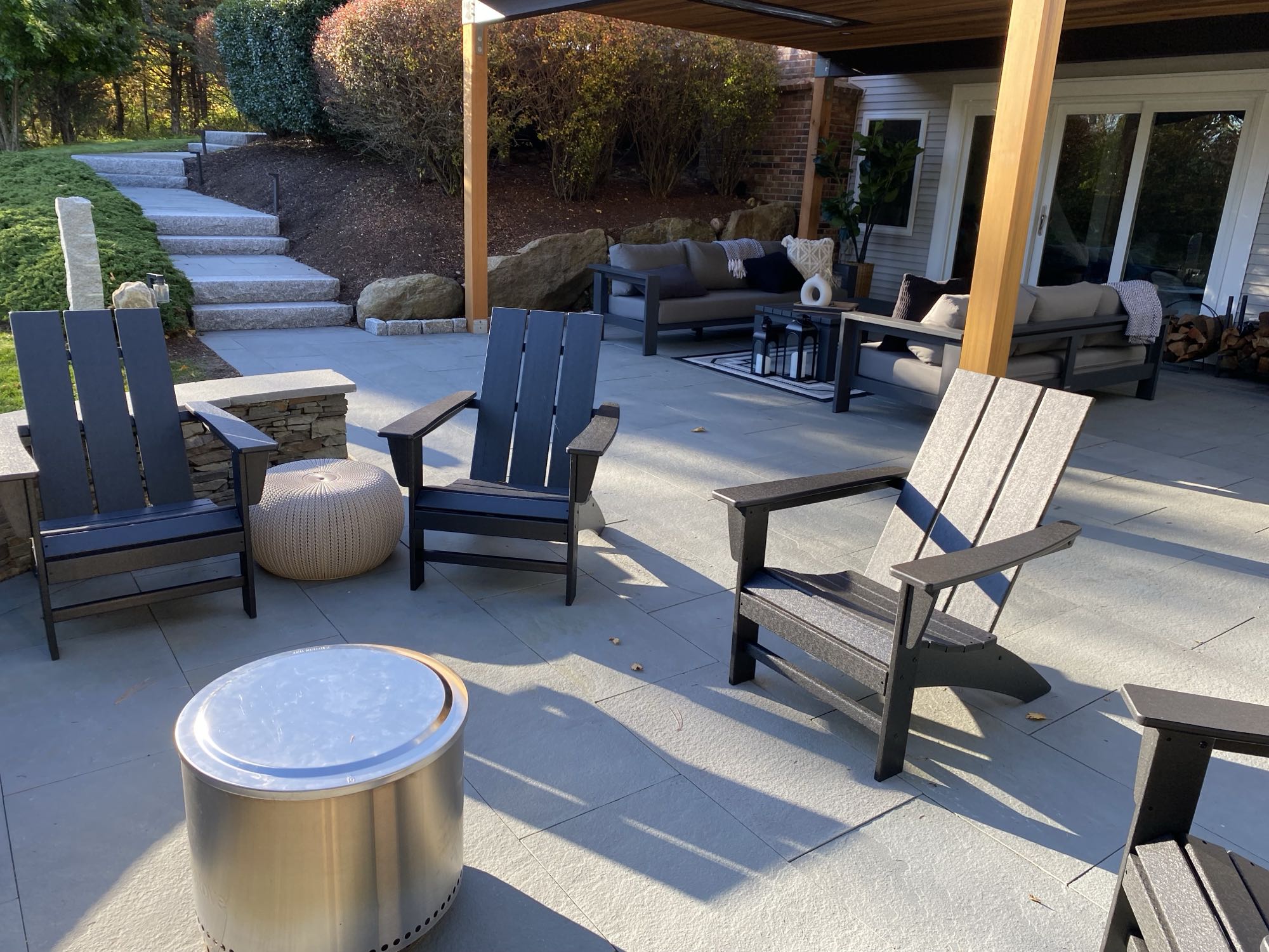 Wild Rose project; large stone patio with covered seating area, fire pit, and large stone slab stairs