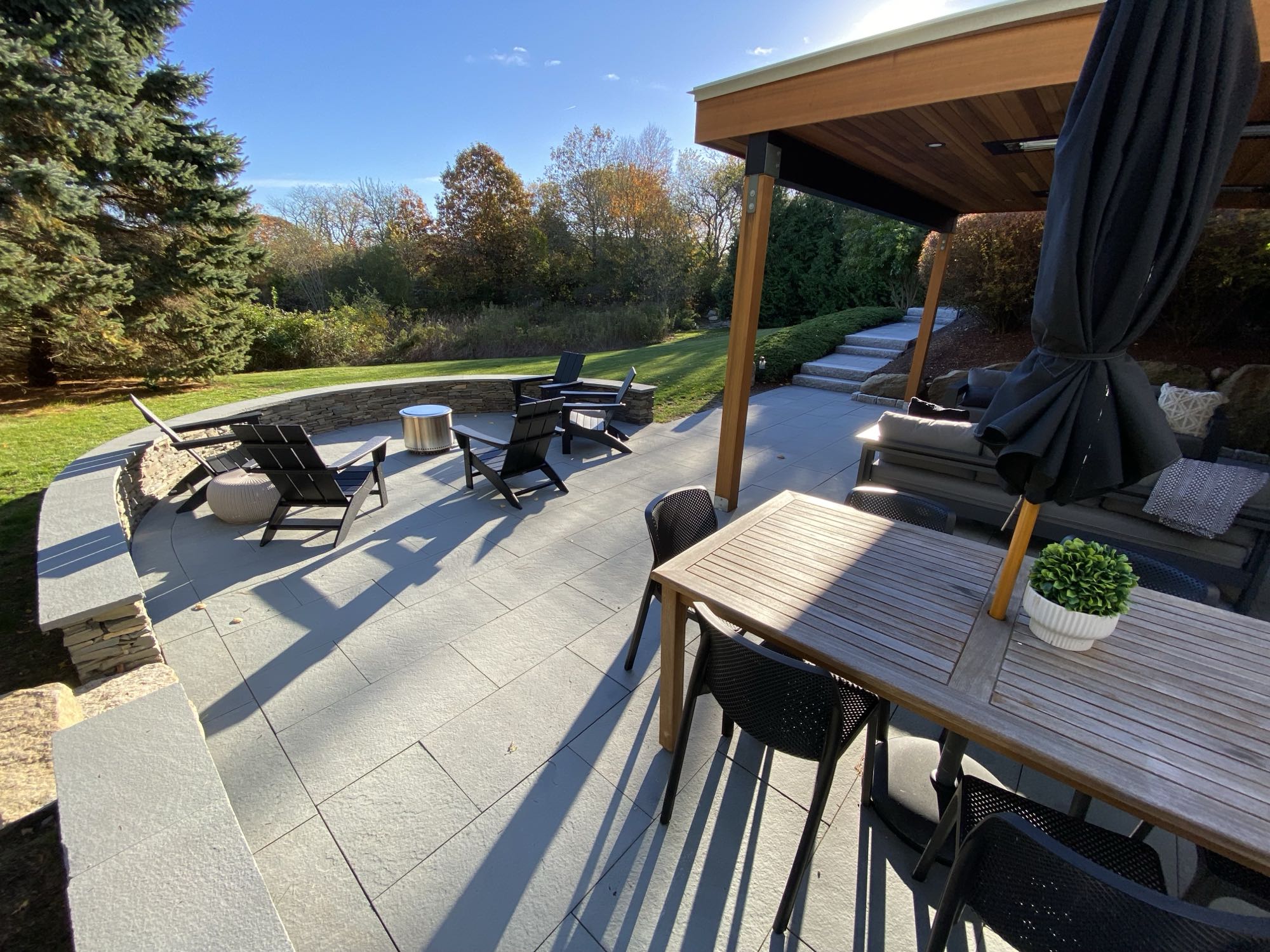 Wild Rose project; large stone patio with border wall, covered seating area, fire pit, and large stone slab stairs