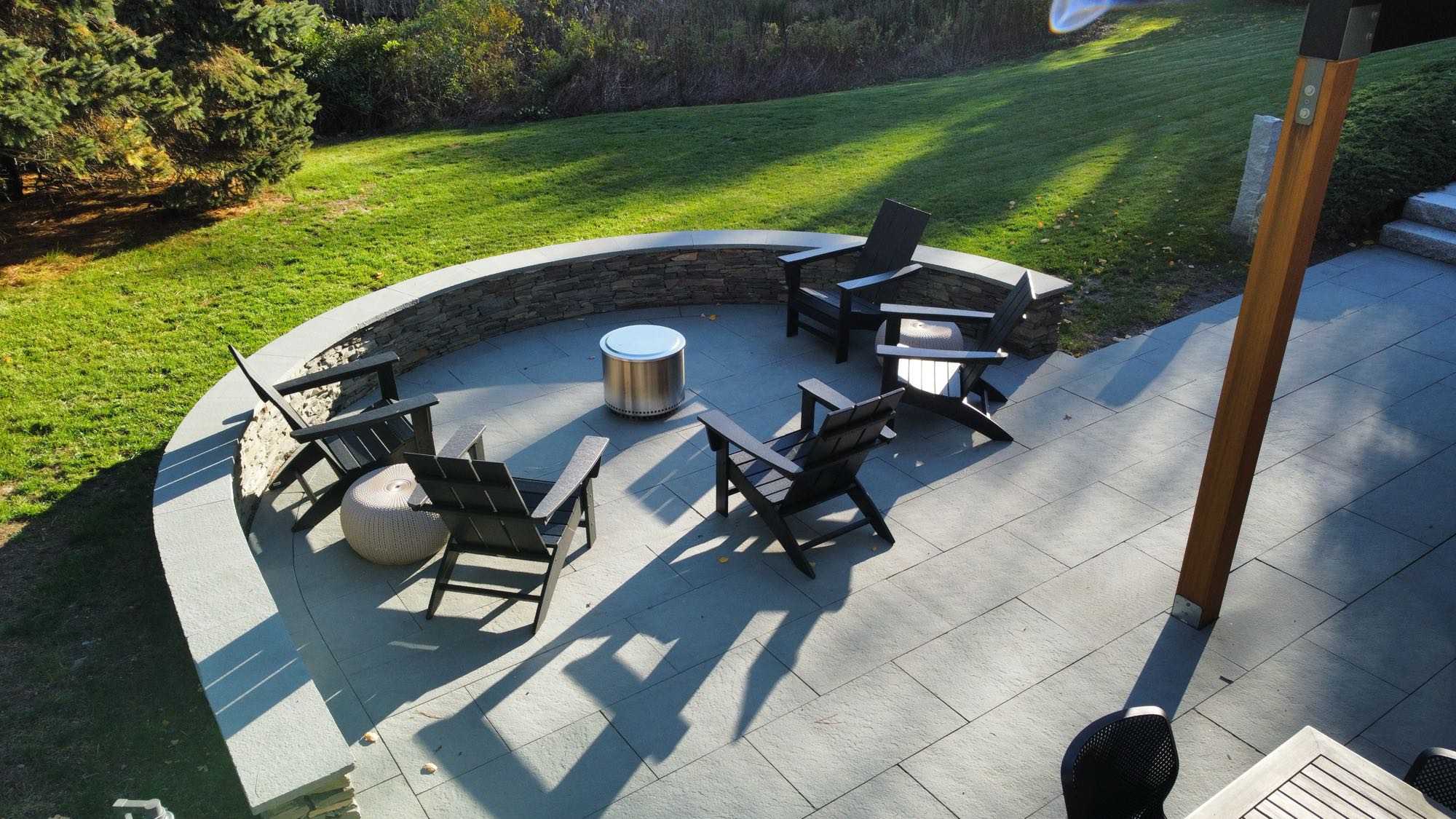 Wild Rose project; large stone patio with border wall and fire pit