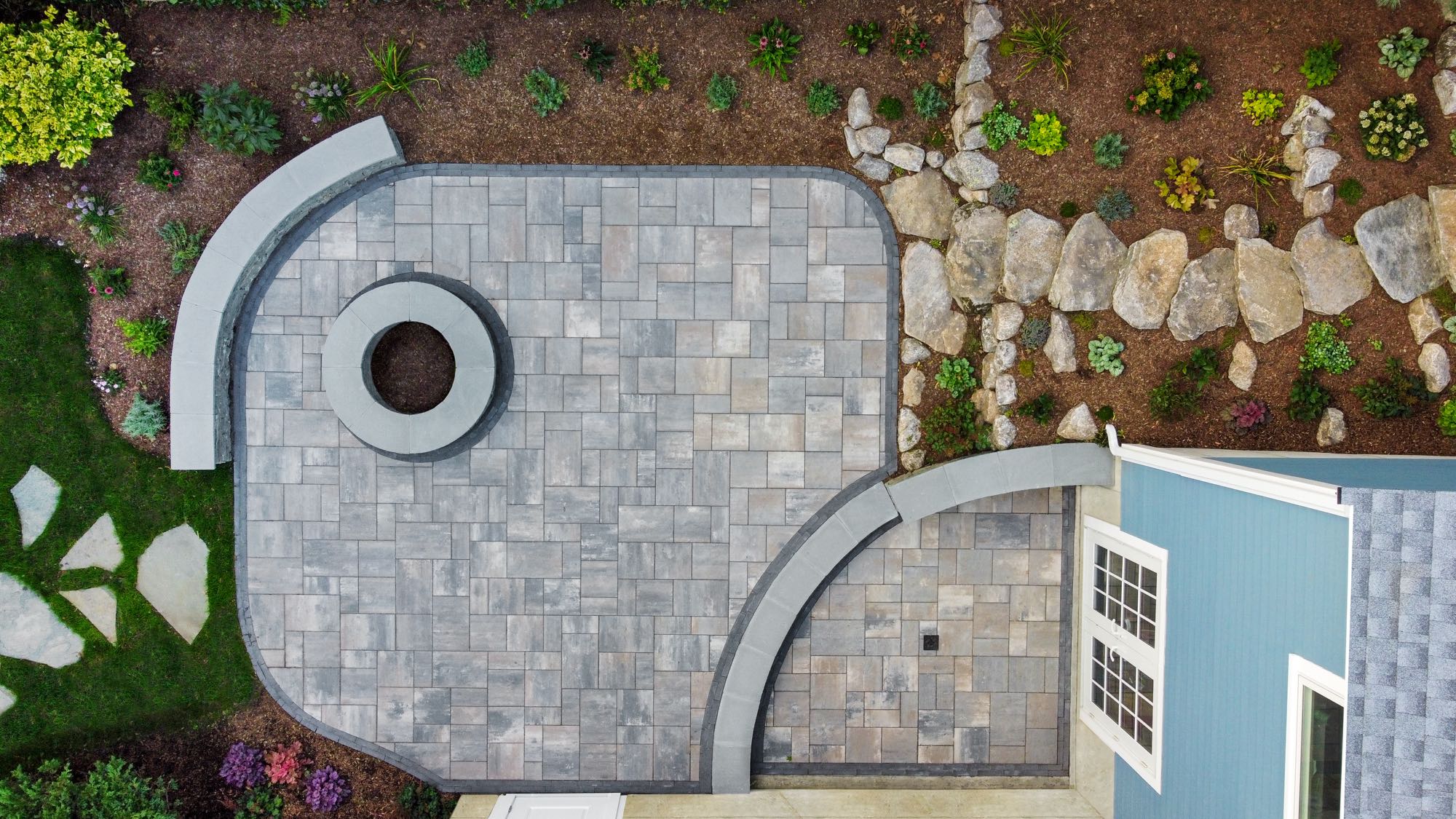 Wolcott Ave project; overhead view of paver patio with two levels, built-in fire pit, and natural stone stair walkway