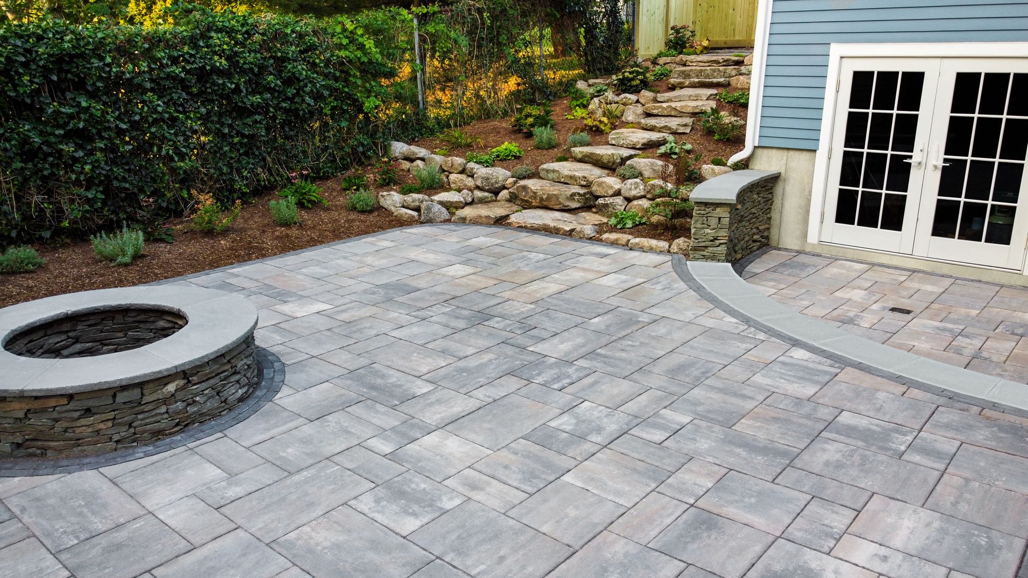 Wolcott Ave project; paver patio with two levels, built-in fire pit, and natural stone stair walkway