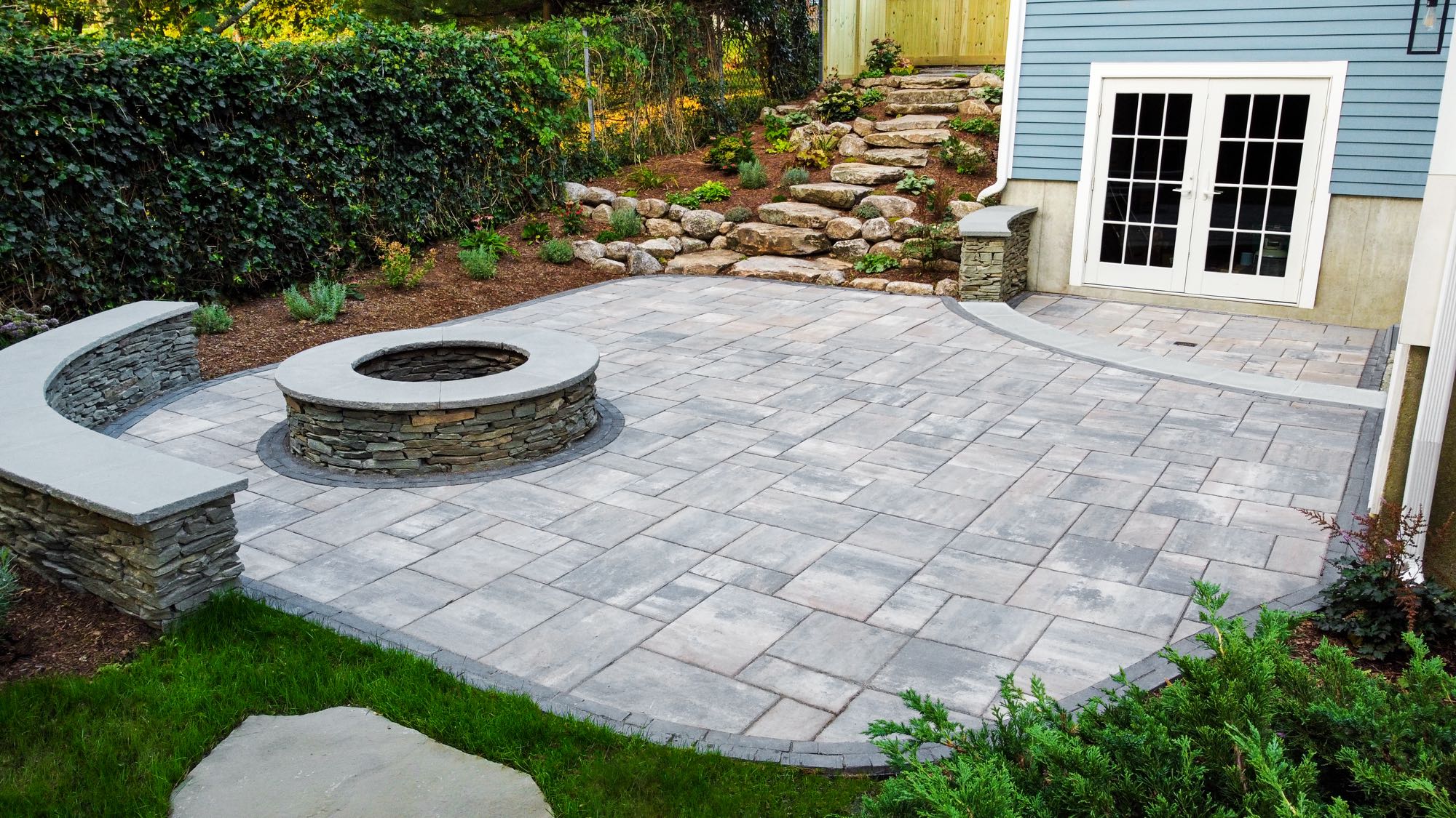 Wolcott Ave project; overhead view of paver patio with two levels, built-in fire pit, and natural stone stair walkway