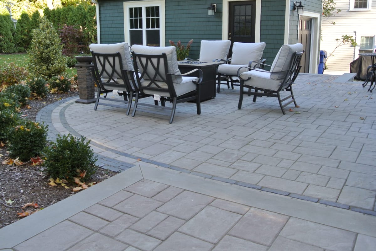 paver patio with a fire pit lounge set in front of a stylish garage