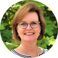 smiling middle-aged woman with short hair and glasses