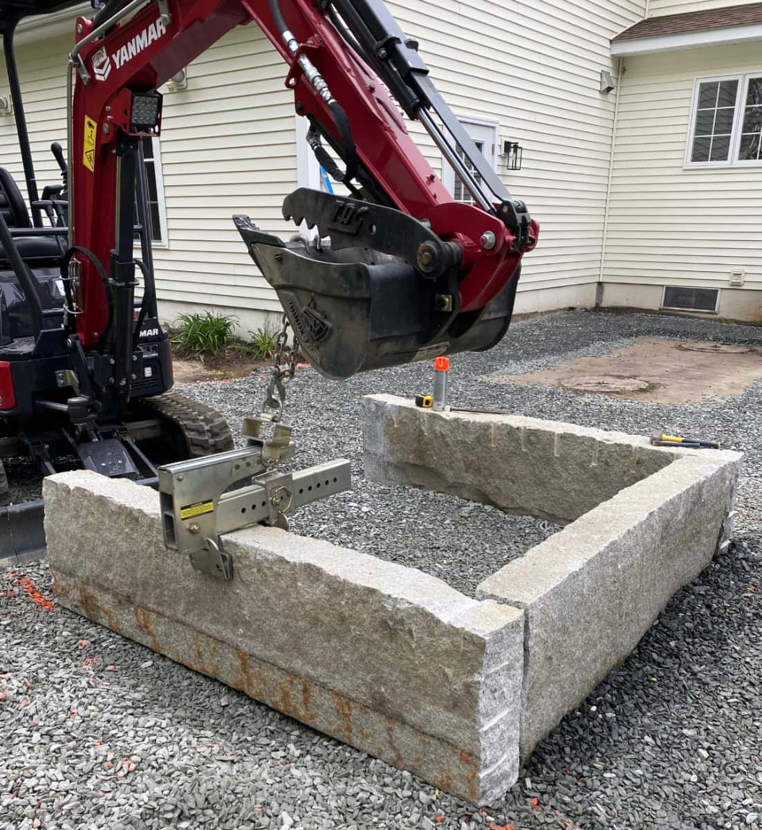 stone fire pit being built with large machinery