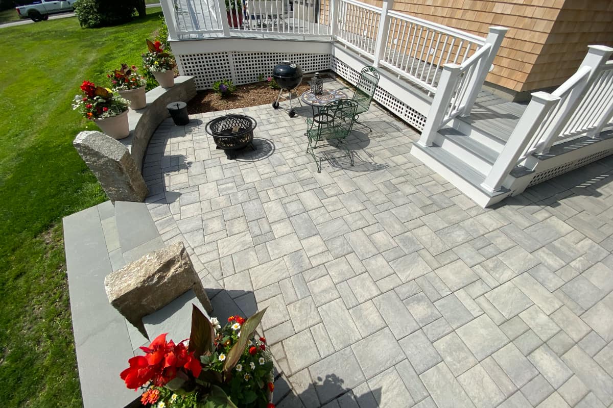 small paver patio attached to deck with fire pit area