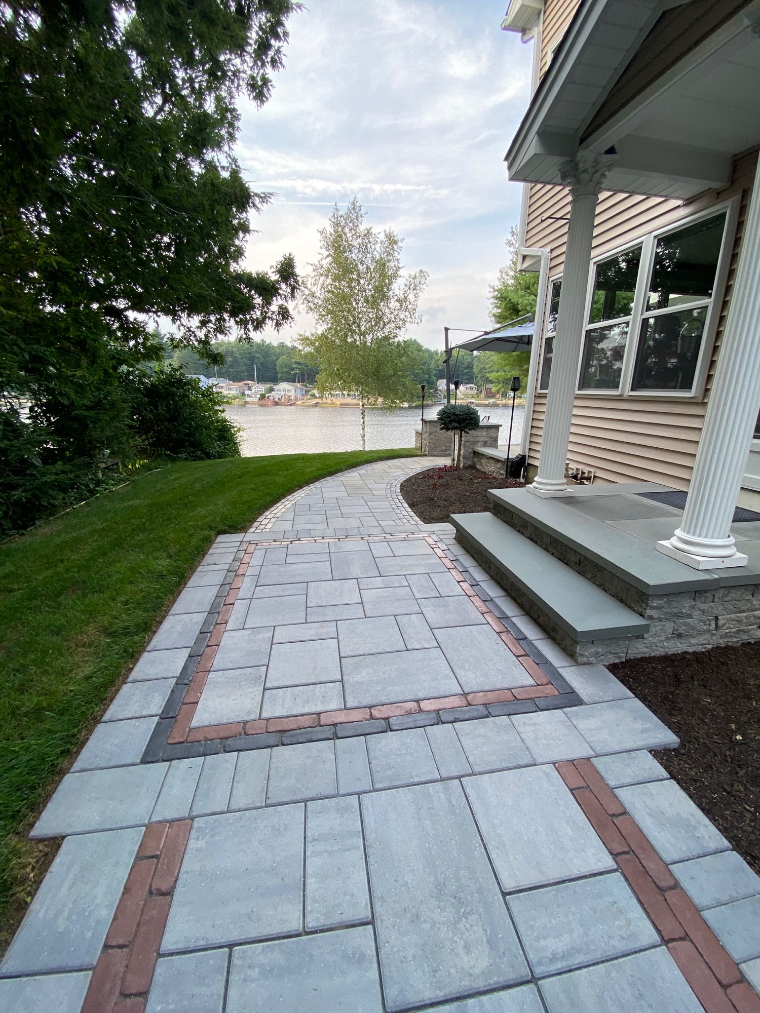 paver walkway leading around side and back of lake house