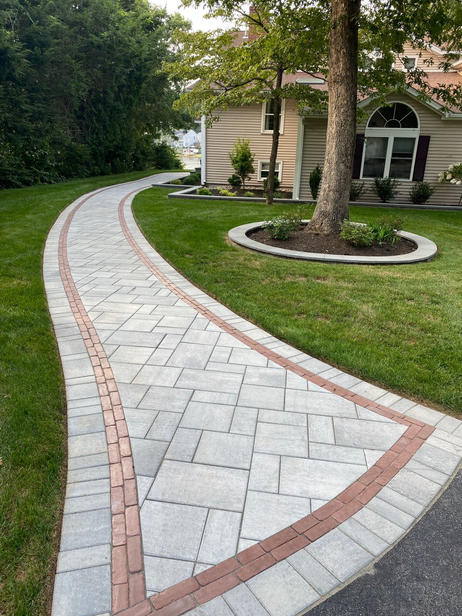 paver walkways with border pattern leading around side of house