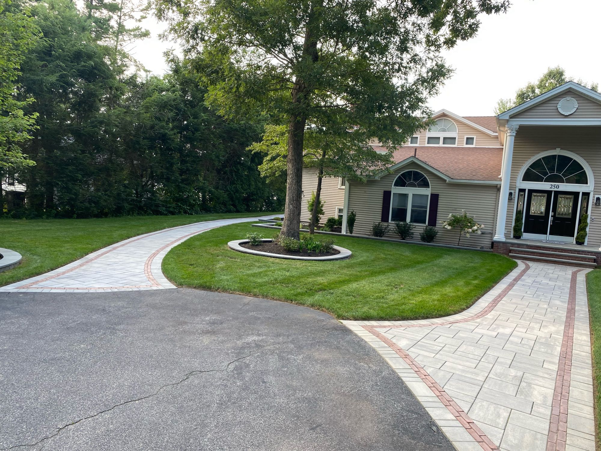 paver walkways with border pattern leading to front door and around side of house