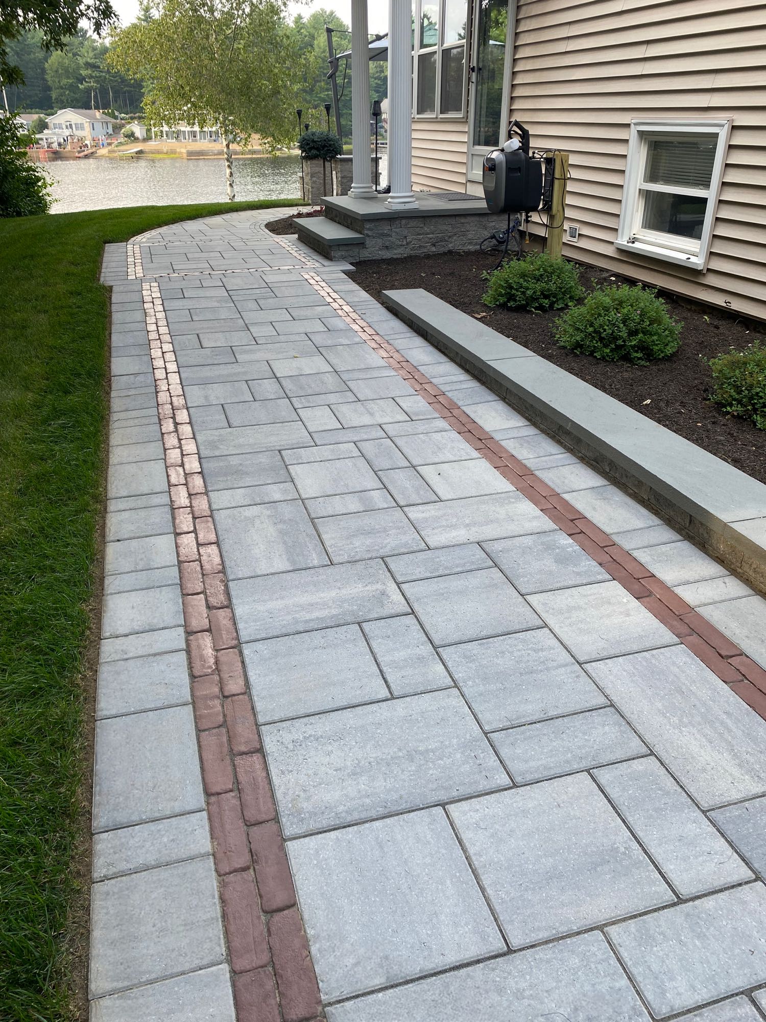 paver walkway leading around side and back of lake house