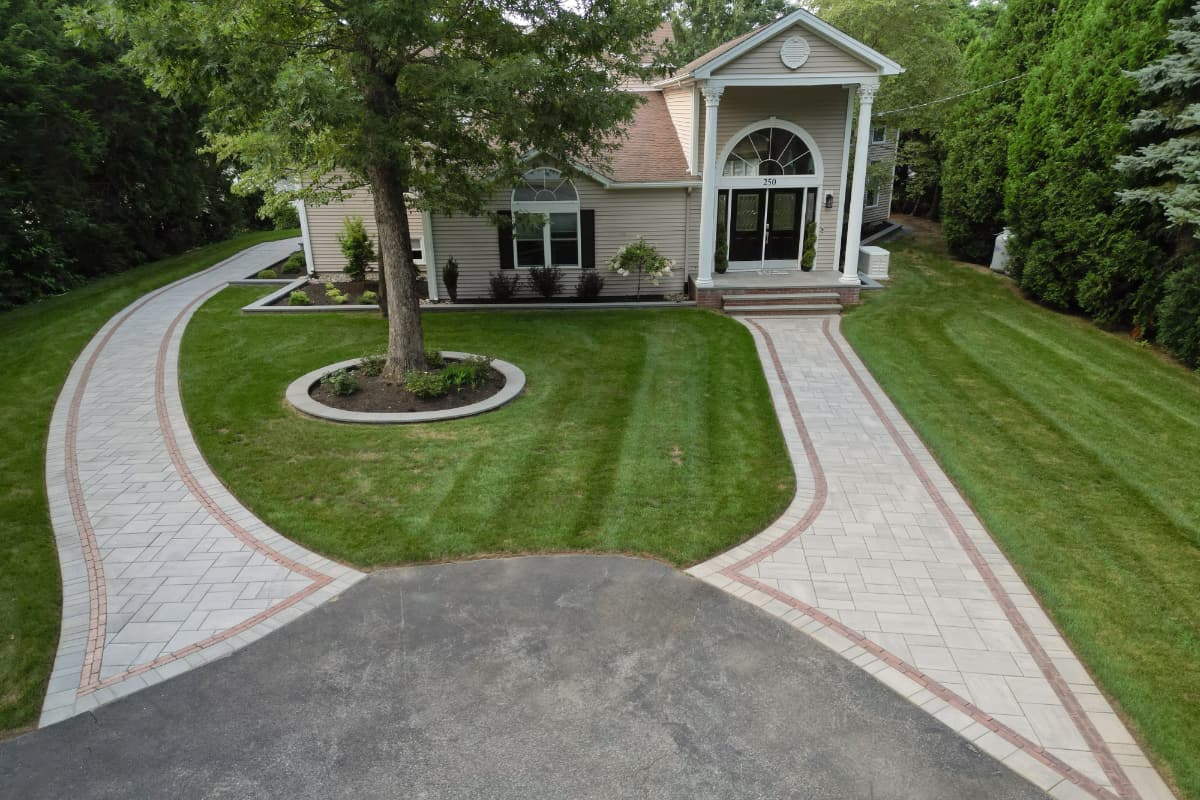 paver walkways with border pattern leading to front door and around side of house