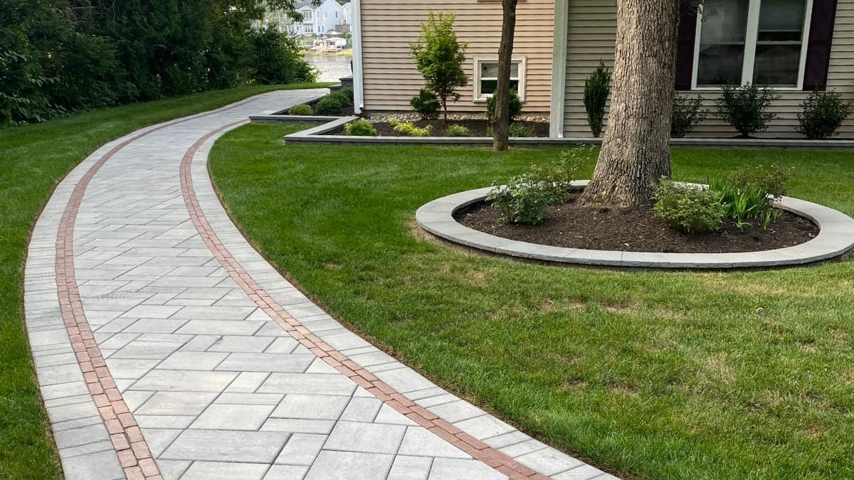 paver walkway curving around the side of a home